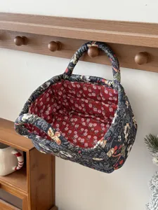 Fabric quilted storage basket hanging detail, dark floral exterior and red floral interior.