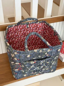 Gesteppter Stoff Aufbewahrungskorb Detail mit floralem Muster, praktischen Griffen und Innenraum.