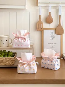 Close-up of cute polka dot tissue pouch featuring drawstring design in a warm kitchen setting.