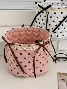 Cute quilted cylindrical storage basket with polka dots, lace trim and bows for desktop.