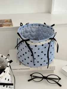 Close-up detail of the blue quilted polka dot storage basket with cute black bows and lace.