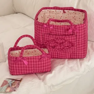 Pink plaid quilted storage basket with cute bows and floral lining, perfect for home organization.