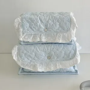 Light blue quilted fabric storage basket with white lace ruffle, cute desktop organizer box.