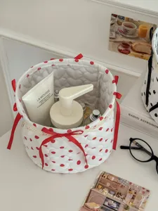 White quilted polka dot storage basket with red bows, fabric round desktop organizer container.