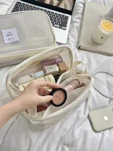 Detailansicht der cremeweißen Mesh-Kosmetiktasche mit mehreren Fächern für Reiseaufbewahrung.