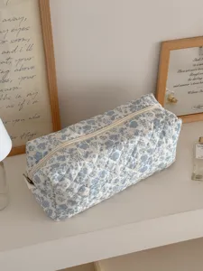 Dettaglio della borsa trapuntata con fiori blu, elegante custodia da viaggio per accessori e trucco.