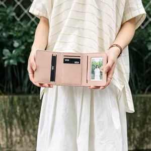 Pink trifold wallet for women with multiple card slots and clear photo window, compact and stylish.
