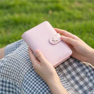 Carnet en cuir verni rose gros plan avec fermoir en etoile et finitions detaillees