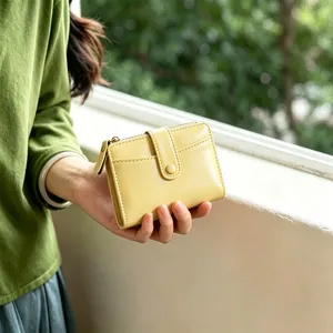 Close-up shot of the yellow mini folding wallet featuring card slots and zipper coin pocket.