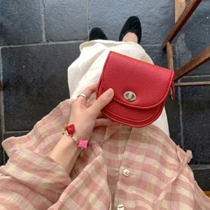 Red leather small round coin purse for women, fashionable twist lock minimalist shoulder bag.