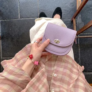 Discover this chic purple mini saddle bag featuring a stylish turn-lock and soft leather.