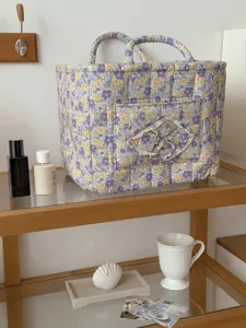 Gesteppter floraler Aufbewahrungskorb mit Doppelgriffen und Vordertasche für Zuhause.