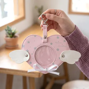 Portabadge in ecopelle a forma di cuore rosa con ali d'angelo e fiocco decorativo