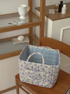 Detailansicht eines floralen Stepp-Aufbewahrungskorbs mit Karomuster, gemütlicher Wohnstil.