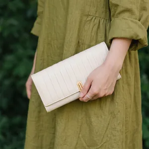 Vue détaillée du portefeuille long minimaliste, cuir beige, design à rayures élégantes.