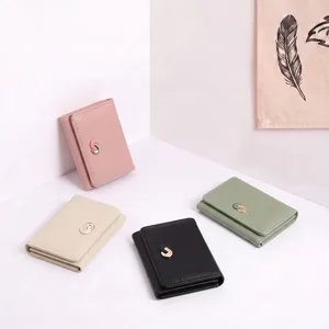 Detail view of multi-color minimalist trifold wallets featuring chic metal clasps.