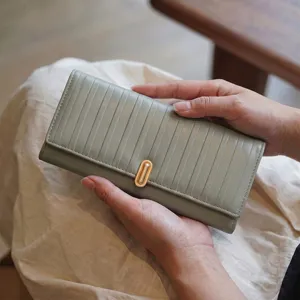 Portefeuille long pour femme élégant avec rayures verticales et fermoir doré raffiné.