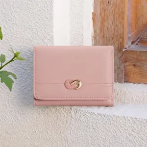 Detail view of a pink minimalist tri-fold wallet with a stylish metal clasp and card slots.
