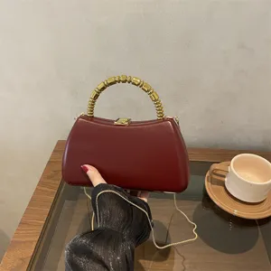 Dark red PU hard shell evening bag with unique gold beaded handle and chain strap detail.