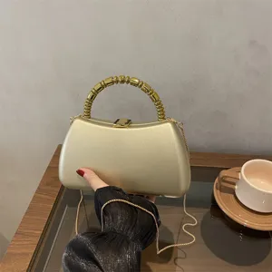 Details of luxury gold hard shell evening clutch bag with beaded handle and chain strap.