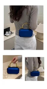 Blue acrylic box handbag detail showing geometric cut design and gold chain shoulder strap.