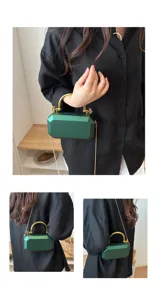 Close-up view of the dark green acrylic box bag, highlighting gold handle and chain details.