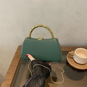 Dark green PU hard-shell evening bag detail, featuring unique gold beaded handle and metal chain.