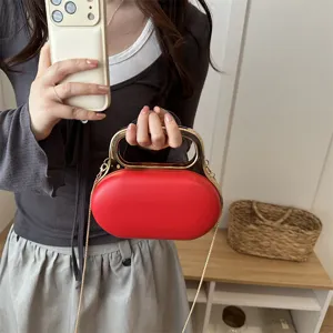 Red acrylic clutch handbag with gold handle and chain strap, elegant evening shoulder bag.