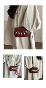 Elegante burgunderrote Acryl Box Clutch mit goldener Kette und Metall Kralle Detail.