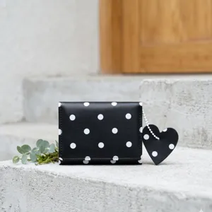 Portafoglio donna a pois neri con ciondolo a cuore, astuccio carte minimalista dettaglio.