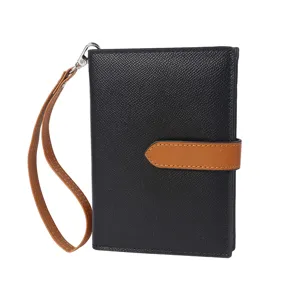 Close-up detail of the black and brown passport holder, showcasing the wrist strap and buckle.