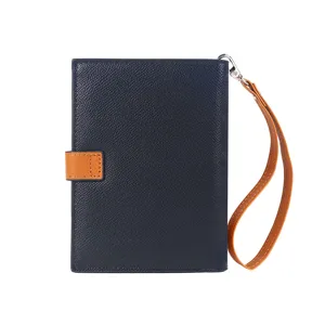 Close-up detail view of the contrast color passport wallet showcasing the buckle and wrist strap.