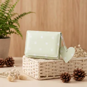 Portafoglio verde menta a pois con grazioso ciondolo a cuore in stile minimalista.