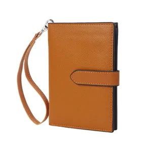 Brown Saffiano passport wallet with wrist strap and snap closure for travel and business.