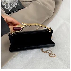 Elegante zwarte avondtas met metalen bloemhandvat en kettingriem voor vrouwen.