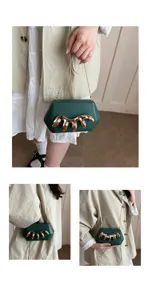 Detailansicht der dunkelgrünen Acryl-Clutch mit einzigartigem goldener Klauen-Strass-Dekor.