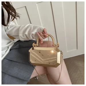 Metallic geometric evening clutch bag detail view with chain strap and handle