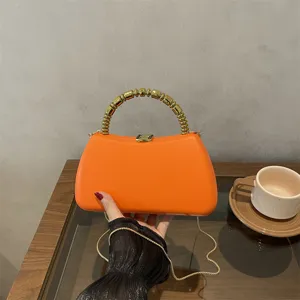 Trendy PU hard shell evening bag with chic golden beaded handle in candy orange color.