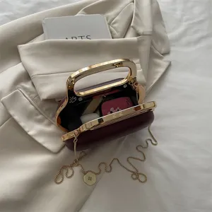 Elegant metal frame evening clutch bag with gold handle and chain strap for women chic style.