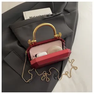 Red acrylic box bag with gold handle and chain strap, elegant evening handbag for women.