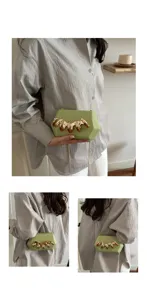 Detailansicht der hellgrünen Acryl Clutch Tasche mit goldenem Klauendesign und Kette.