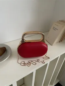 Red acrylic handbag with metallic handle and chain strap, elegant evening crossbody bag.