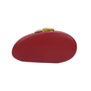 Λεπτομέρεια κόκκινης τσάντας clutch από PU δέρμα σε σχήμα βότσαλου με μεταλλικό κούμπωμα.