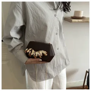 Dunkelbraune Clutch mit goldener Kralle und Strass, schicke Kette fur elegante Damen.