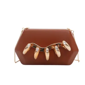 Detailansicht der eleganten braunen Acryl-Abendtasche mit Goldkette und Strass-Krallen.
