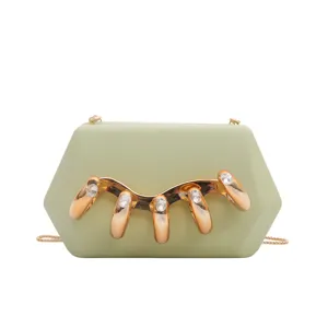 Nahaufnahme der grünen Acryl Clutch Tasche mit luxuriösem goldenen Fingerbeschlag und Strass.
