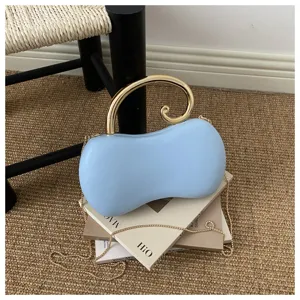 Vista dettaglio della borsa da sera in PU azzurro con manico dorato e catena chic.