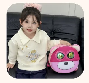 Detailaufnahme des süßen rosa Cartoon EVA Schalenrucksacks mit Model auf dem Ledersofa.
