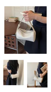 Detail view of stylish white woven cylinder shoulder bag for women, elegant daily wear.