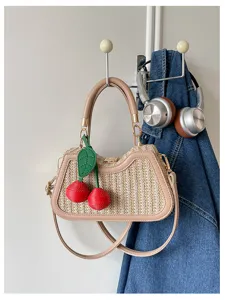Vue détaillée du sac à bandoulière en paille d'été avec charmante cerise pour les vacances.